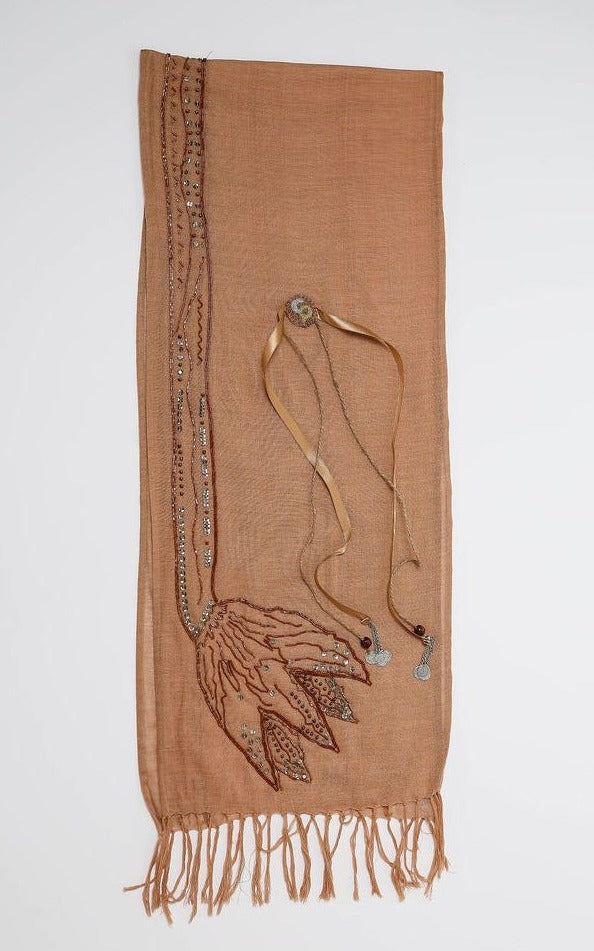 De duurzame, handgemaakte, betekenisvolle Tulip sjaal in beige die elegant gedrapeerd is en een intrigerend patroon van verweven kleuren en texturen laat zien