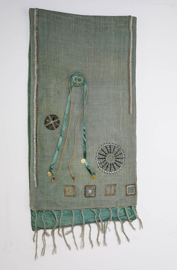 De duurzame, handgemaakte, betekenisvolle, gevoerde Full Circle sjaal die elegant gedrapeerd is en een intrigerend patroon van verweven kleuren en texturen laat zien