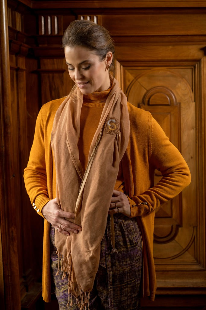 De duurzame, handgemaakte, betekenisvolle Luxe sjaal die elegant gedrapeerd is en een intrigerend patroon van verweven kleuren en texturen laat zien