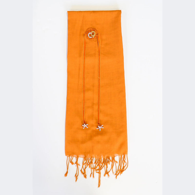 De duurzame, handgemaakte, betekenisvolle Flower Friends sjaal die elegant gedrapeerd is en een intrigerend patroon van verweven kleuren en texturen laat zien