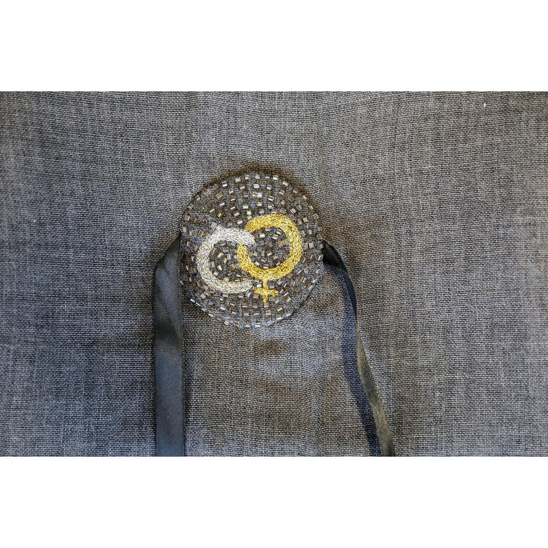 De duurzame, handgemaakte, betekenisvolle Flower Friends sjaal die elegant gedrapeerd is en een intrigerend patroon van verweven kleuren en texturen laat zien