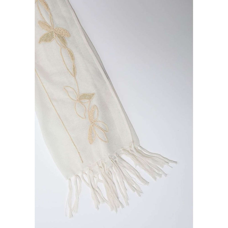 De duurzame, handgemaakte, betekenisvolle Leaves sjaal in wit die elegant gedrapeerd is en een intrigerend patroon van verweven kleuren en texturen laat zien