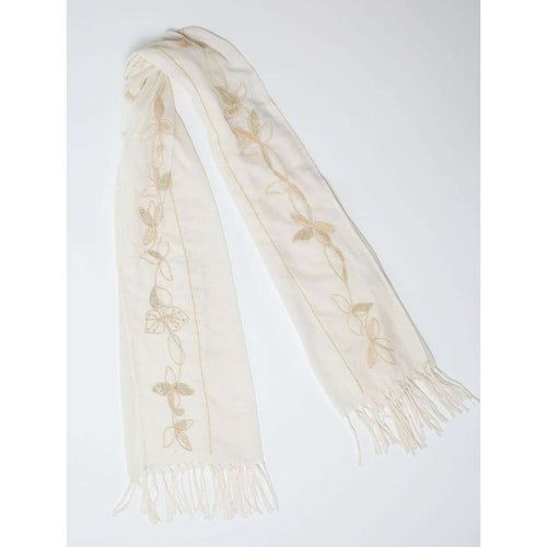 De duurzame, handgemaakte, betekenisvolle Leaves sjaal in wit die elegant gedrapeerd is en een intrigerend patroon van verweven kleuren en texturen laat zien