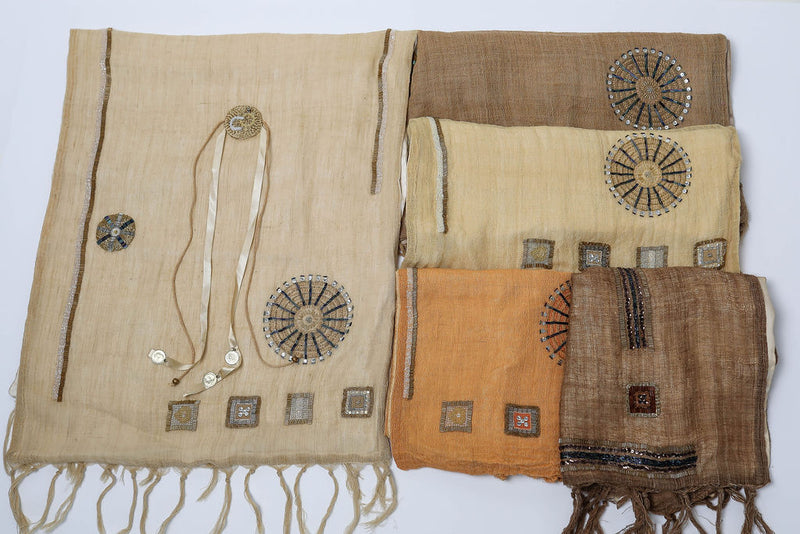 De duurzame, handgemaakte, betekenisvolle, gevoerde Full Circle sjaal die elegant gedrapeerd is en een intrigerend patroon van verweven kleuren en texturen laat zien