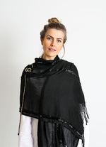 De duurzame, handgemaakte, betekenisvolle Stripe sjaal in zwart die elegant gedrapeerd is en een intrigerend patroon van verweven kleuren en texturen laat zien
