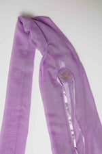 De duurzame, handgemaakte, betekenisvolle Luxe sjaal in lila die elegant gedrapeerd is en een intrigerend patroon van verweven kleuren en texturen laat zien