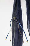 De duurzame, handgemaakte, betekenisvolle Stripe sjaal in donkerblauw die elegant gedrapeerd is en een intrigerend patroon van verweven kleuren en texturen laat zien