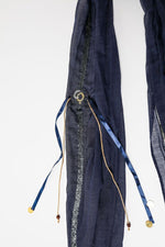 De duurzame, handgemaakte, betekenisvolle Stripe sjaal in donkerblauw die elegant gedrapeerd is en een intrigerend patroon van verweven kleuren en texturen laat zien