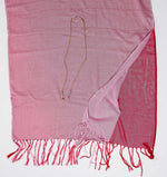 De duurzame, handgemaakte, betekenisvolle Big Duo sjaal in roze en rood die elegant gedrapeerd is en een intrigerend patroon van verweven kleuren en texturen laat zien