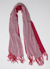 De duurzame, handgemaakte, betekenisvolle Big Duo sjaal in roze en rood die elegant gedrapeerd is en een intrigerend patroon van verweven kleuren en texturen laat zien