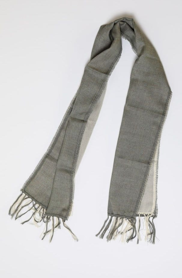 De duurzame, handgemaakte, betekenisvolle Duo sjaal in creme en grijs die elegant gedrapeerd is en een intrigerend patroon van verweven kleuren en texturen laat zien